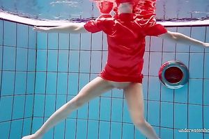 Slender and cute redhead white wife dives in the pool and disrobes underwater
