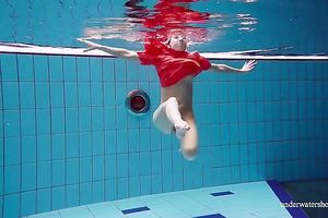 Slender and cute redhead white wife dives in the pool and disrobes underwater