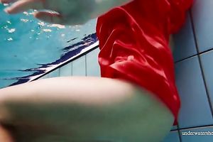 Slender and cute redhead white wife dives in the pool and disrobes underwater