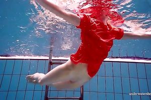 Slender and cute redhead white wife dives in the pool and disrobes underwater