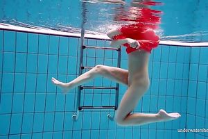 Slender and cute redhead white wife dives in the pool and disrobes underwater