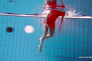 Slender and cute redhead white wife dives in the pool and disrobes underwater