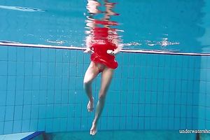 Slender and cute redhead white wife dives in the pool and disrobes underwater