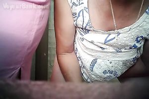 Chunky aged white woman in the biffy room filmed from front