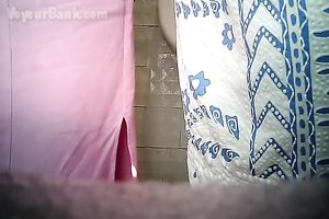 Chunky aged white woman in the biffy room filmed from front