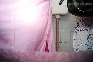 Chunky aged white woman in the biffy room filmed from front