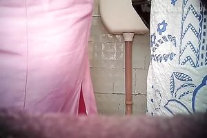 Chunky aged white woman in the biffy room filmed from front