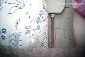 Chunky aged white woman in the biffy room filmed from front