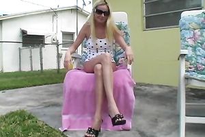 Fuckable lengthy haired blondie finger bonks her shaved vagina sitting on deckchair