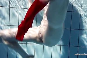 Blonde breasty European teenie in red costume underwater