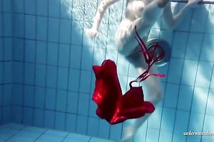 Blonde breasty European teenie in red costume underwater