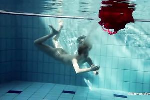Blonde breasty European teenie in red costume underwater