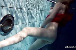 Blonde breasty European teenie in red costume underwater