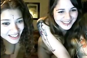 Two lubricious coeds with tattoos are fooling around in front of a webcam