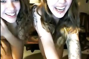 Two lubricious coeds with tattoos are fooling around in front of a webcam