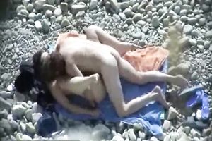 Naughty white milf rides her partner on the exposed beach
