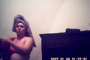 Hidden camera of lustful bulky dark brown putting on her raiment after shower