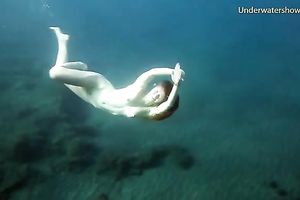 Cute redhead legal age teenager sweetheart in the open blue sea underwater