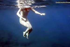 Cute redhead legal age teenager sweetheart in the open blue sea underwater