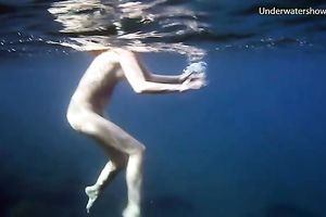 Cute redhead legal age teenager sweetheart in the open blue sea underwater
