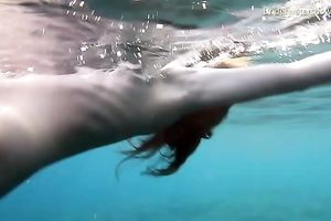 Cute redhead legal age teenager sweetheart in the open blue sea underwater