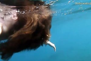 Cute redhead legal age teenager sweetheart in the open blue sea underwater