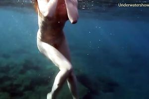 Cute redhead legal age teenager sweetheart in the open blue sea underwater