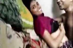 Playful Bangladeshi youthful pair having enjoyment in sofa