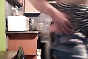 Foureyed older woman stripping in the kitchen
