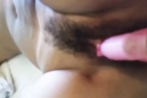 Using a pink bright sex toy lusty girl was petting her bushy muff