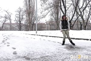 Hot dark brown legal age teenager in the winter coloring snow into yellow