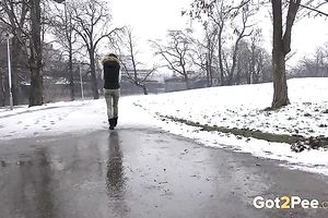 Hot dark brown legal age teenager in the winter coloring snow into yellow