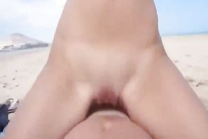 Blonde cute college girlfriend rides her boyfriend on the beach