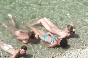 Spying on charming MILFs bathing in the ocean at the naked beach