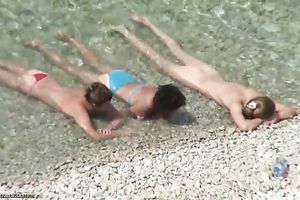 Spying on charming MILFs bathing in the ocean at the naked beach
