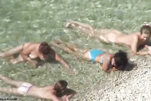 Spying on charming MILFs bathing in the ocean at the naked beach