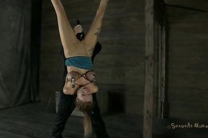 Tattooed perspired slut is hung upside down and teased with dildo