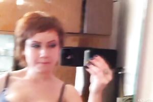 Short haired redhead beauty films herself and disrobes