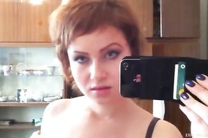Short haired redhead beauty films herself and disrobes