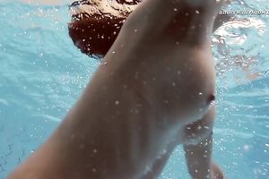 Beautiful brunette hair white white wife beneath water in the pool