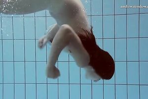 Beautiful brunette hair white white wife beneath water in the pool