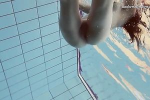 Beautiful brunette hair white white wife beneath water in the pool