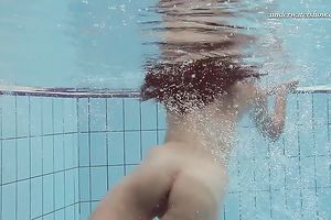 Beautiful brunette hair white white wife beneath water in the pool