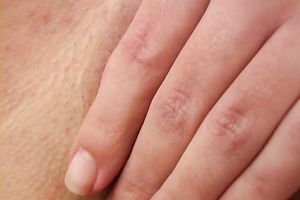 Busty all natural older woman on the sofa plays with her hairless love tunnel