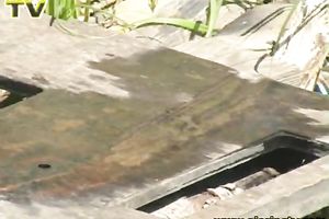 Looking like an alien pale redhead in yellow suit voids urine outdoors