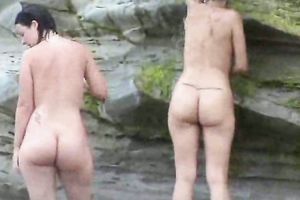 Two curvy Latina women expose their large booties on the stripped beach