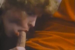 Curly-haired blond mama shows her oral-stimulation skills in retro sex movie scene