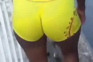 Delicious latin chick arse in yellow and taut bathing shorts