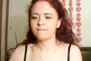Feisty redhead honey positions for camera wearing dark brassiere and diminutive straps