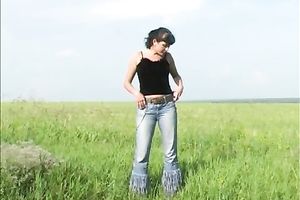 Brunette girl disrobes in the field and pees on the grass
